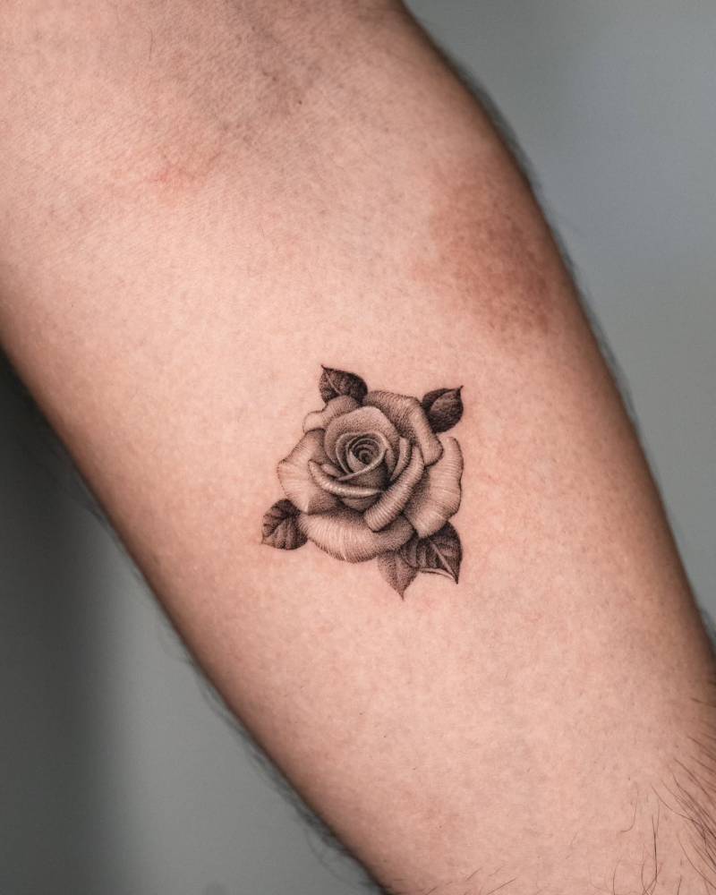 Rose head tattoo in micro-realistic style done on the inner forearm.
