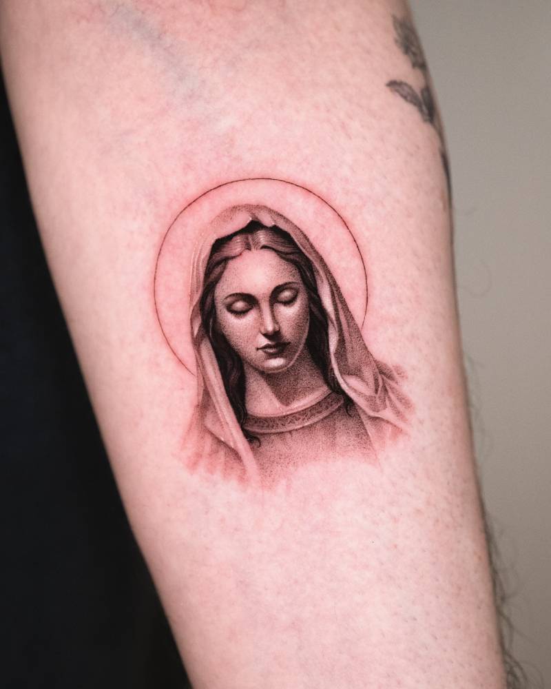 Micro-realistic style Virgin Mary portrait tattoo located on the inner forearm.