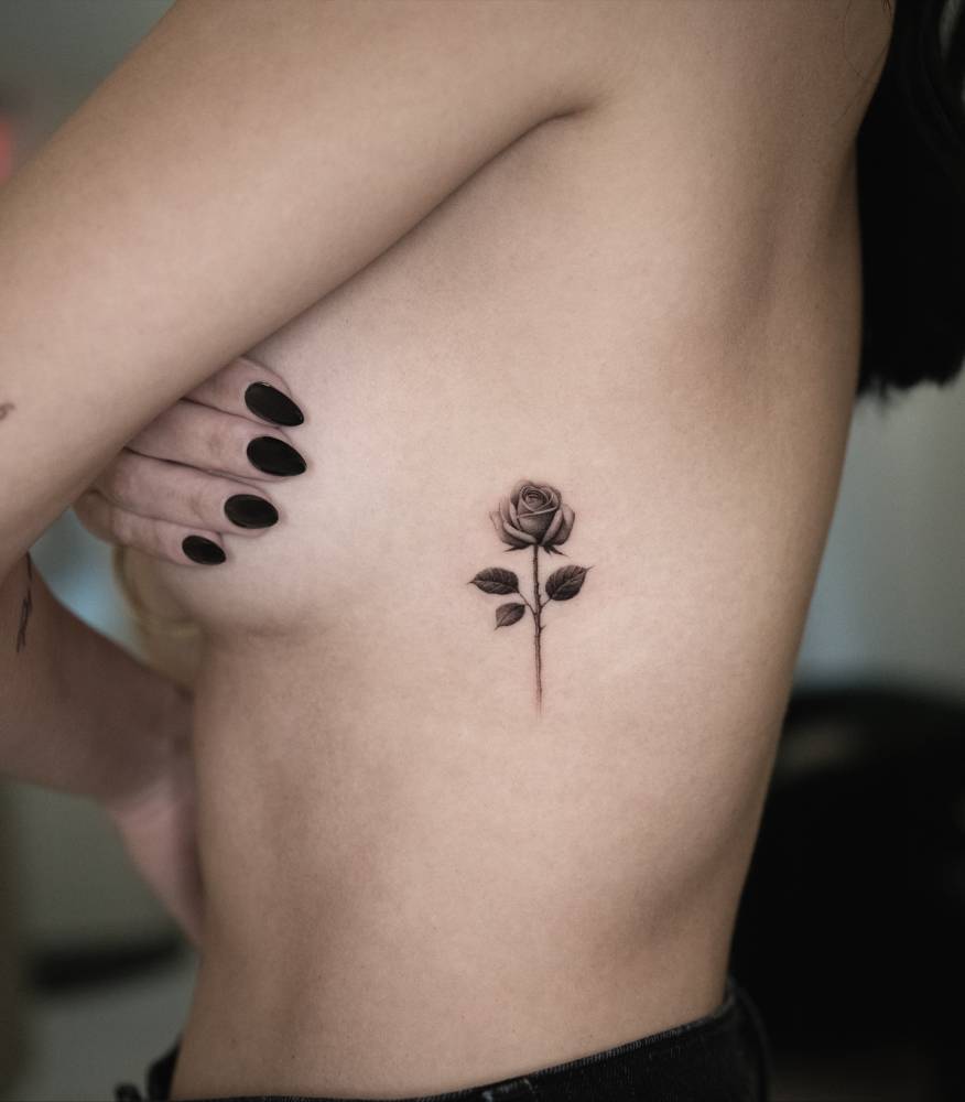 Rose tattoo in micro-realistic style located on the side boob.