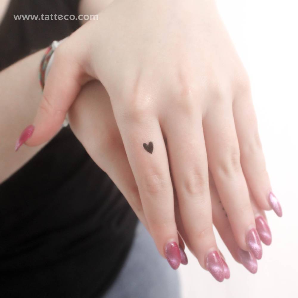 Tiny black heart temporary tattoo located on the finger.