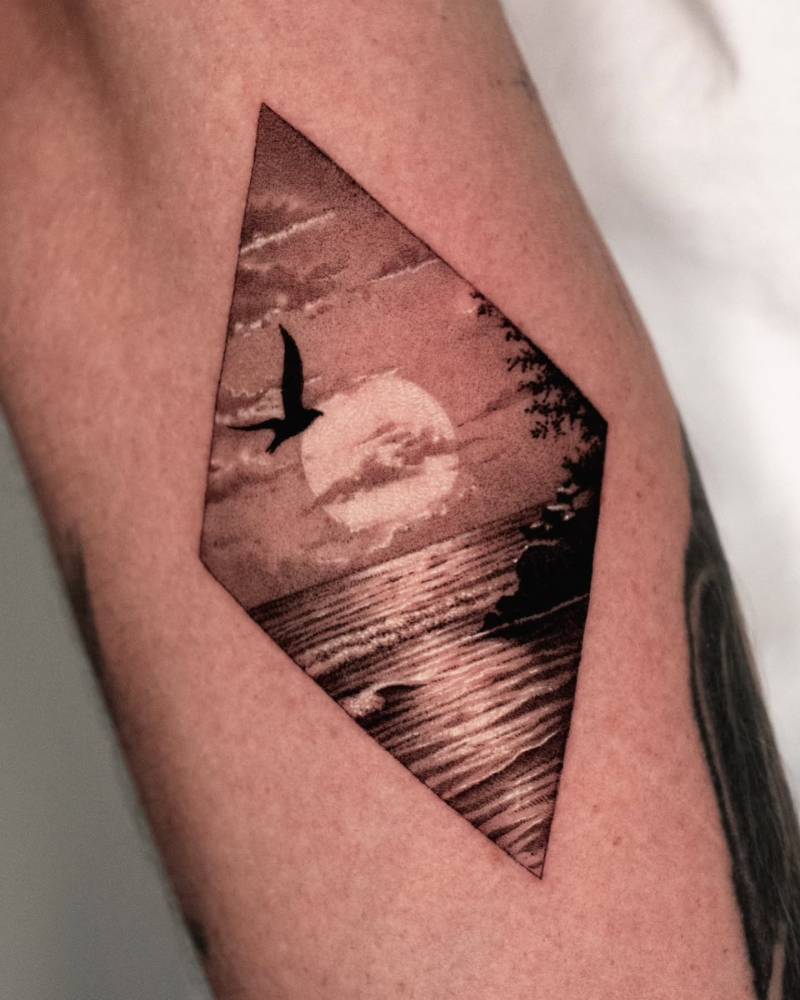 Sea sunset tattoo in micro-realistic style placed on the forearm.