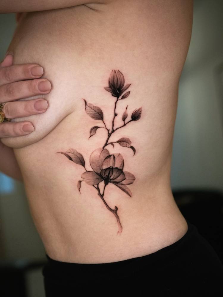 X-ray magnolias tattoo located on the rib, black and grey style.