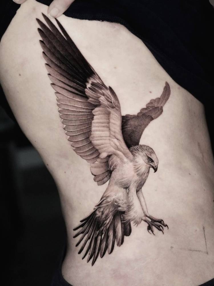 Eagle tattoo in black and grey style located on the rib.