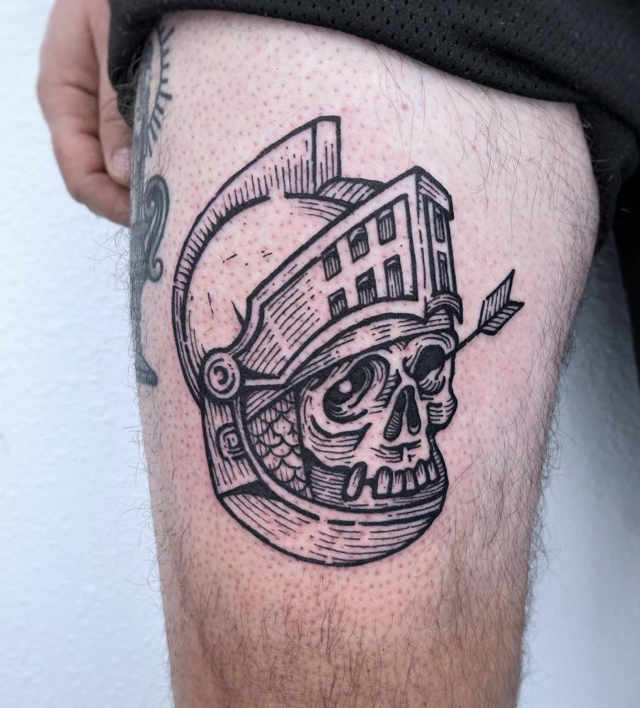 Skull wearing Helmet tattoo located on the thigh, engraving style.