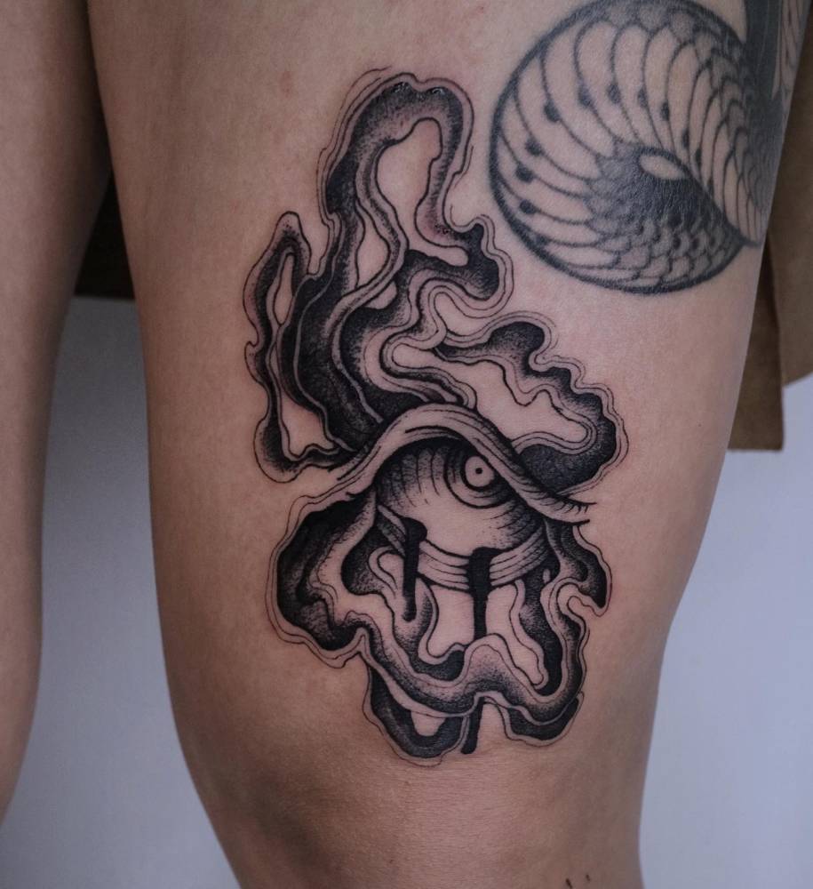 Abstract eye tattoo in engraving style located on the thigh.