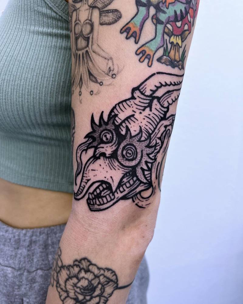 Engraving style dragon tattoo located on the upper arm.