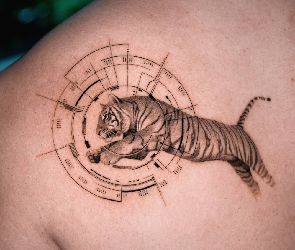 Jumping tiger tattoo in micro-realistic style placed on the shoulder blade.