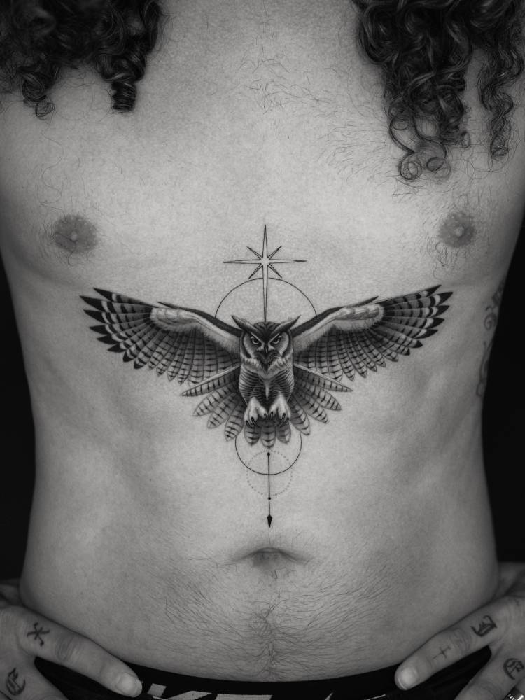 Black and grey owl tattoo located on Mark Ballas' stomach.