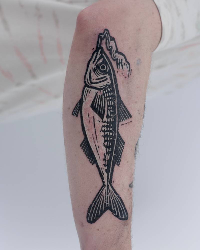 Smoking mackerel tattoo located on the forearm.