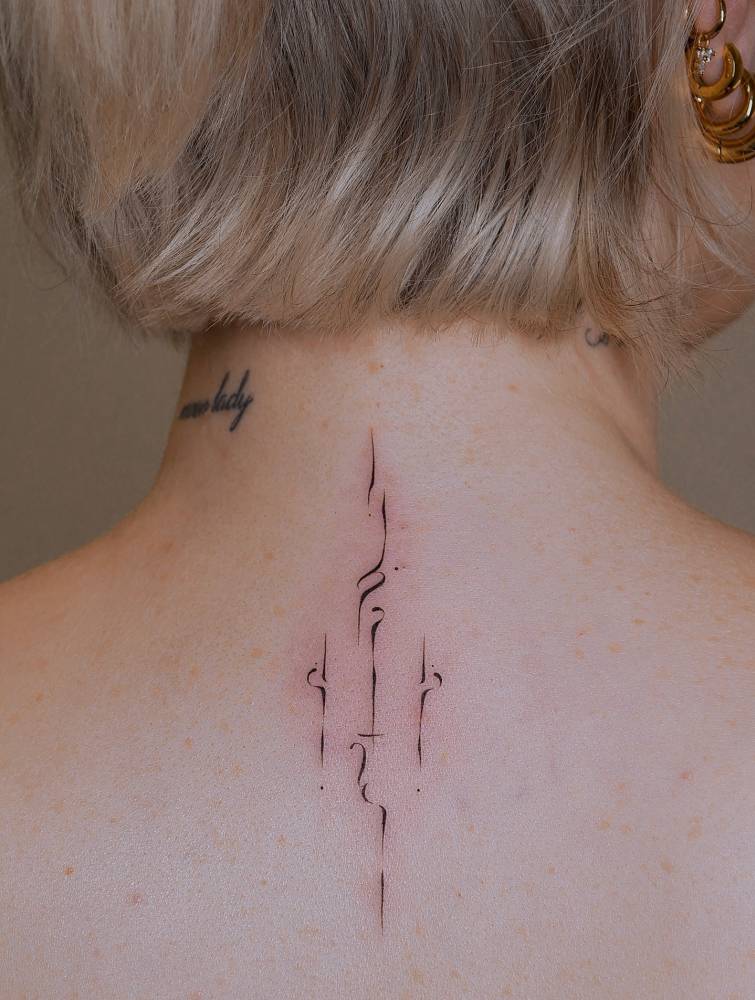 Ornamental tattoo in abstract style located on the upper back.