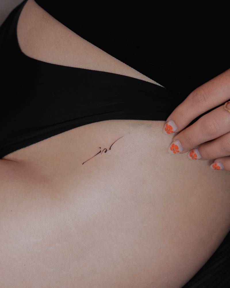 Abstract ornamental tattoo located on the pelvis.