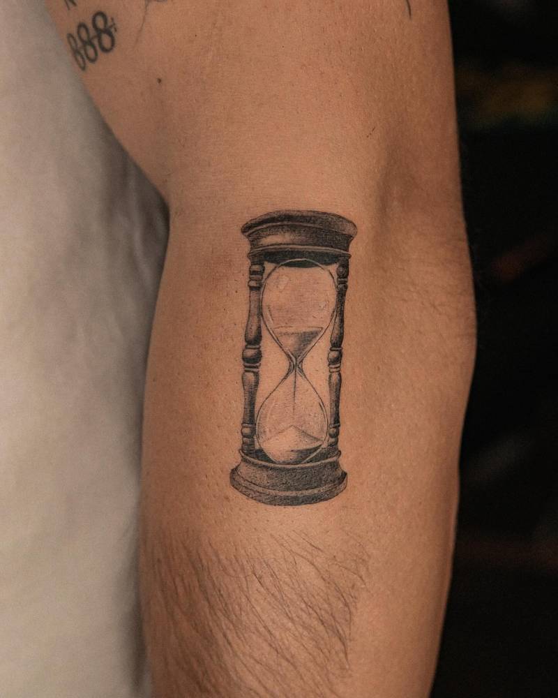 Hourglass tattoo in illustrative style located on the forearm.