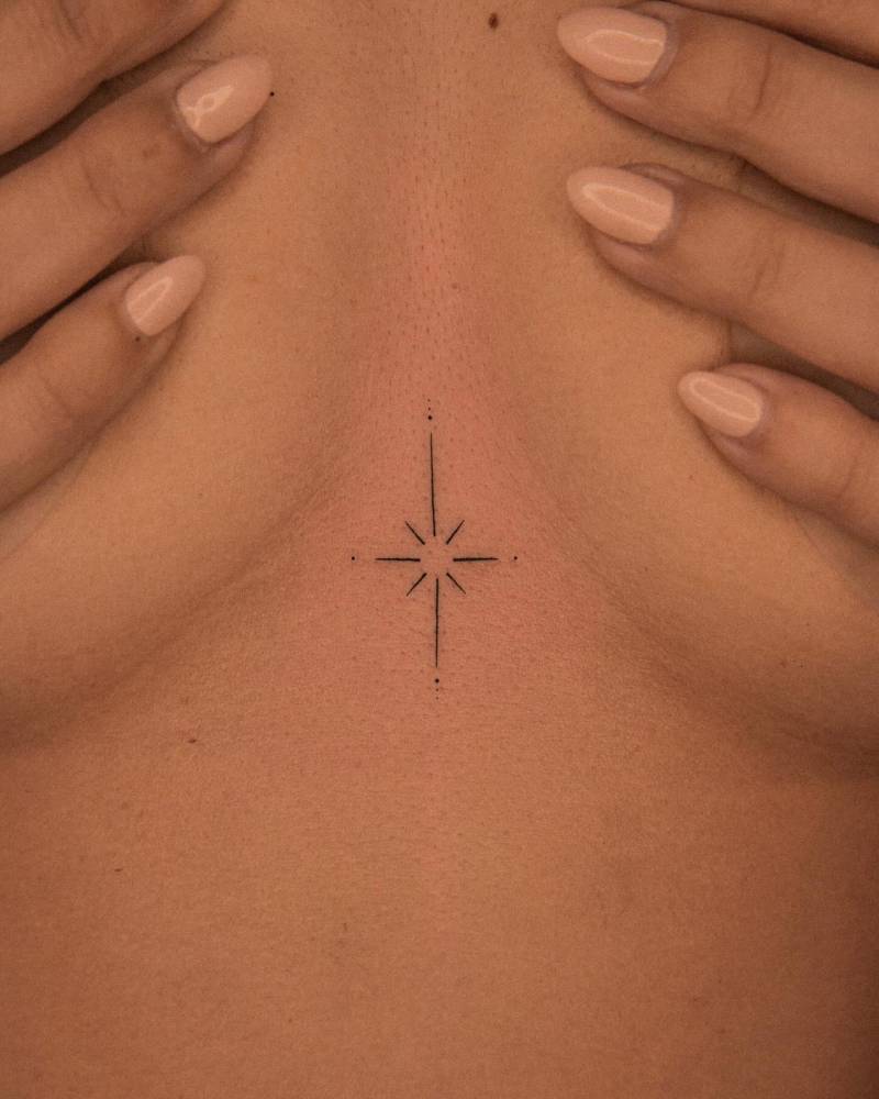 Minimalistic style north star tattoo placed on the sternum.