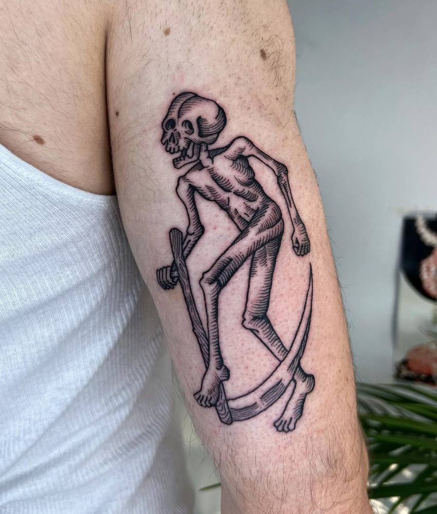 Grim reaper tattoo in engraving style located on thew tricep.