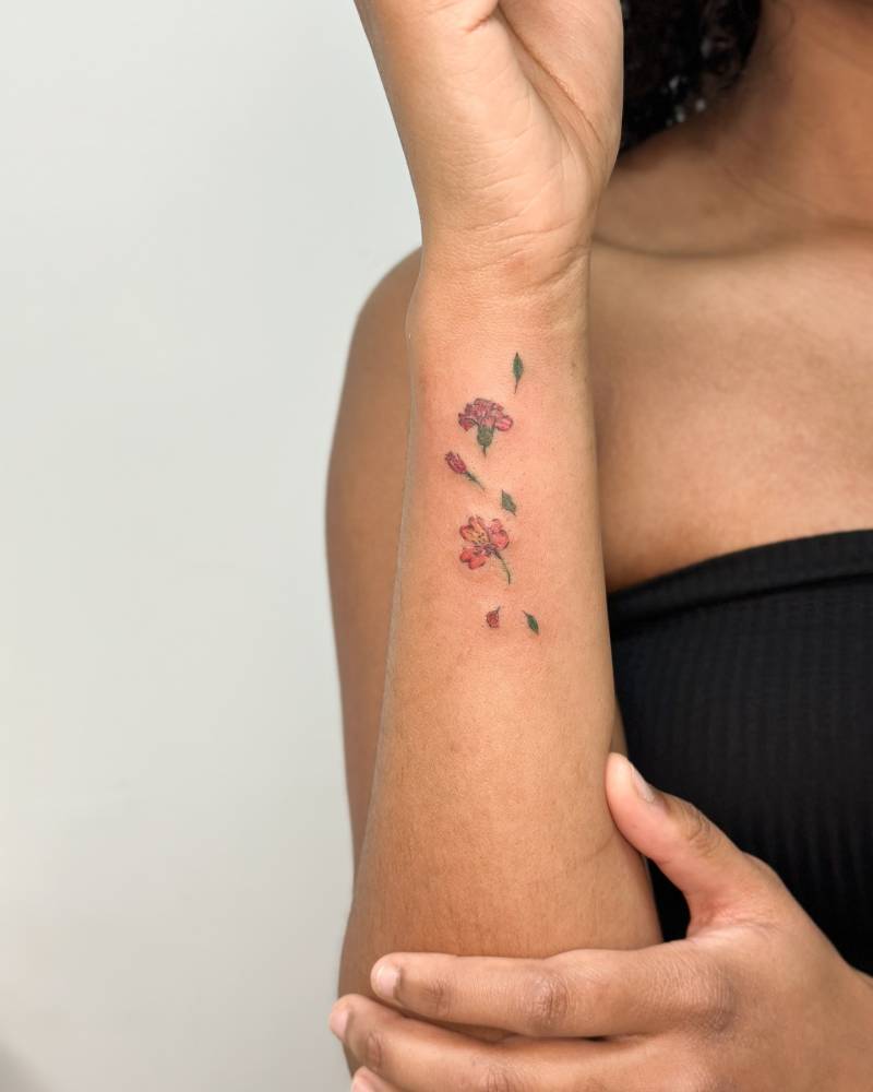 Illustrative style flowers tattoo located on the wrist.