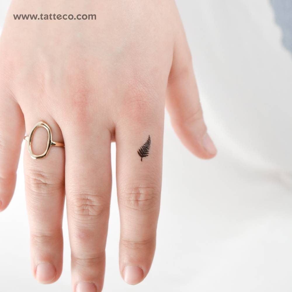 Tiny fern leaf temporary tattoo located on the finger.