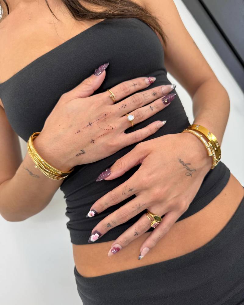 Fine line style ornamental tattoo located on the hand.