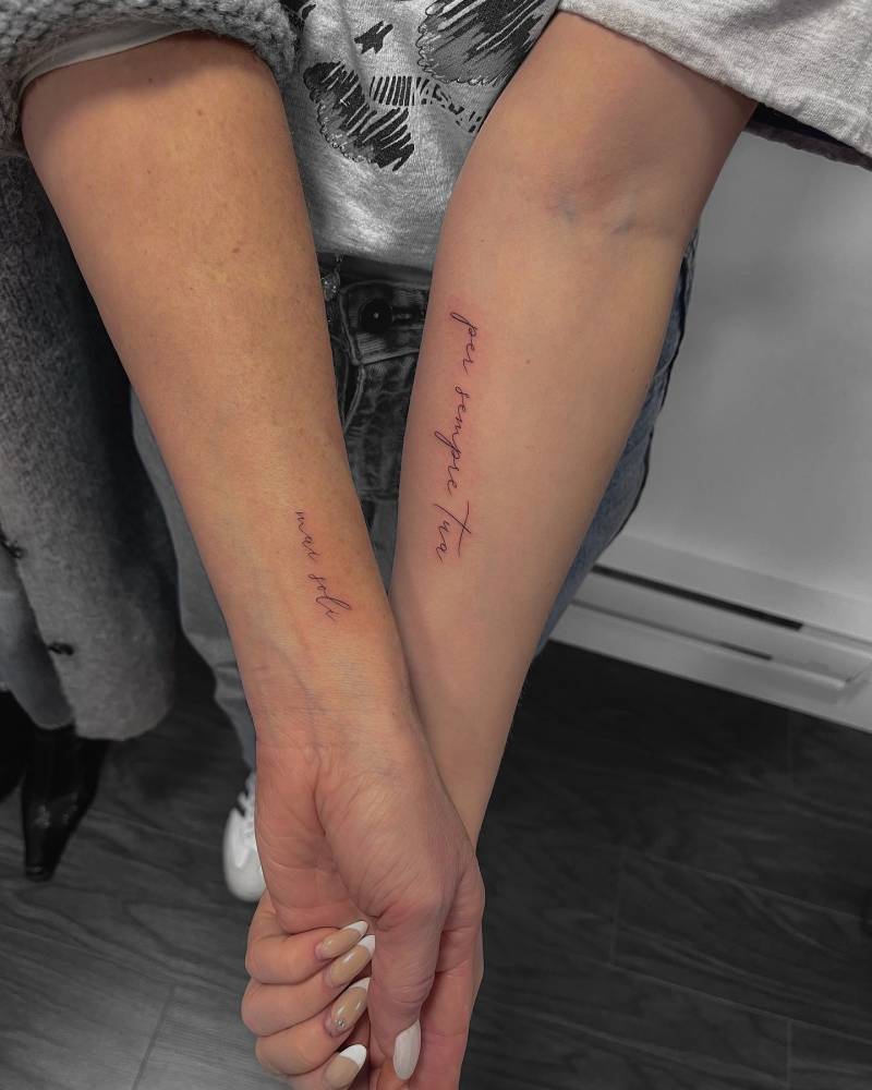 "Mai soli" and "per sempre tua" matching lettering tattoos for mother and daughter.