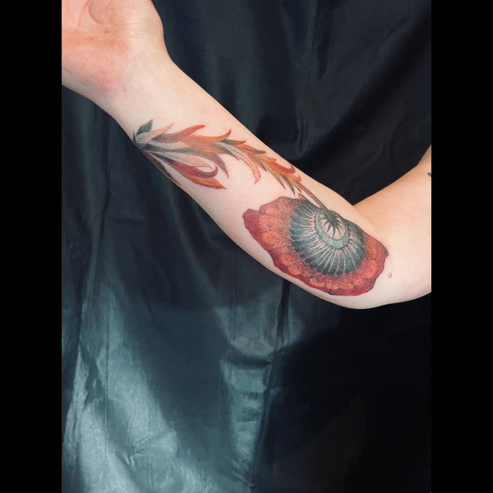 Illustrative style flower tattoo located on the inner forearm.