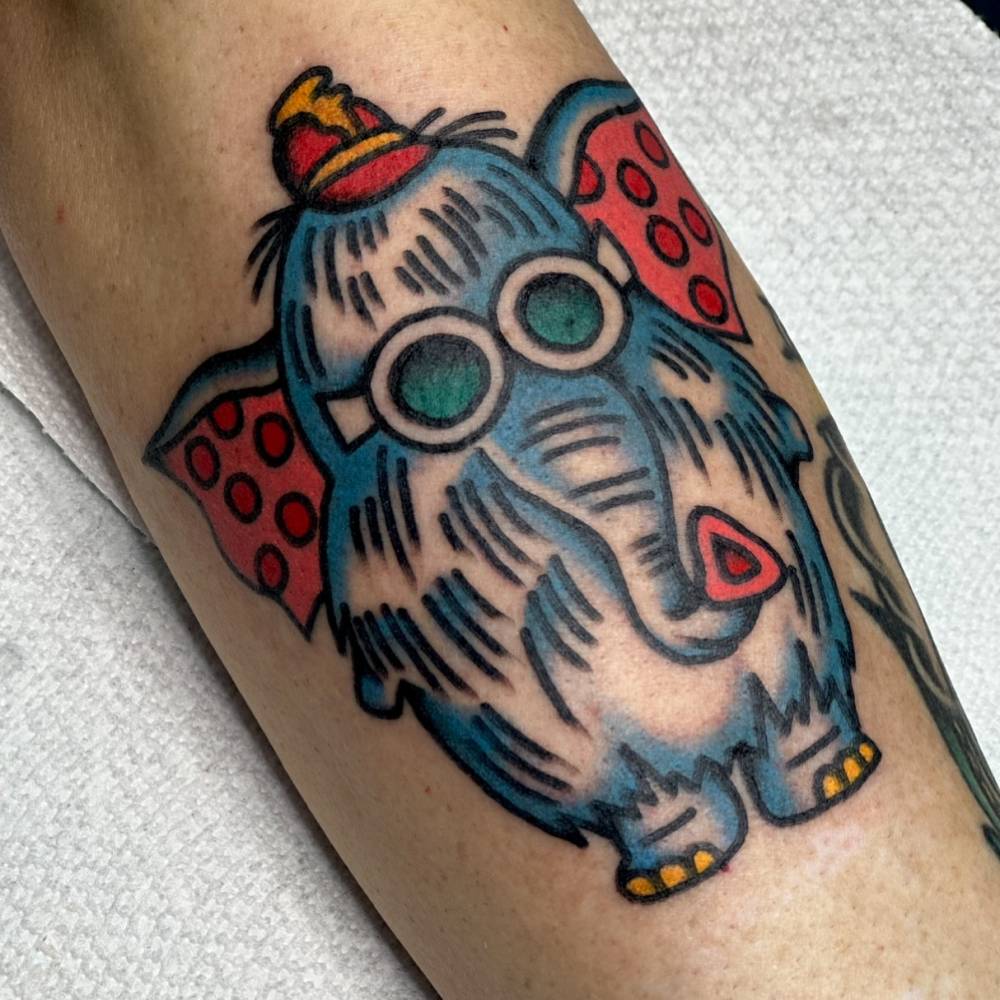 Snorky the Elephant tattoo located on the forearm, traditional style.