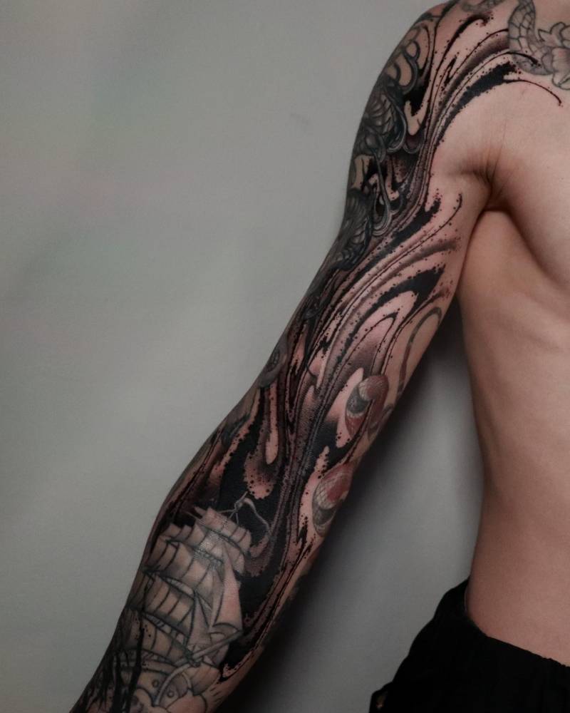 Blackwork style abstract cover up tattoo located on the upper arm.