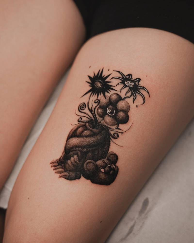 Beheaded teddy bear tattoo located on the thigh.