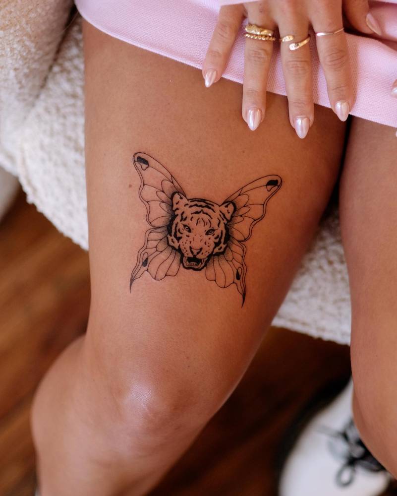 Tiger butterfly tattoo located on the thigh, illustrative style.