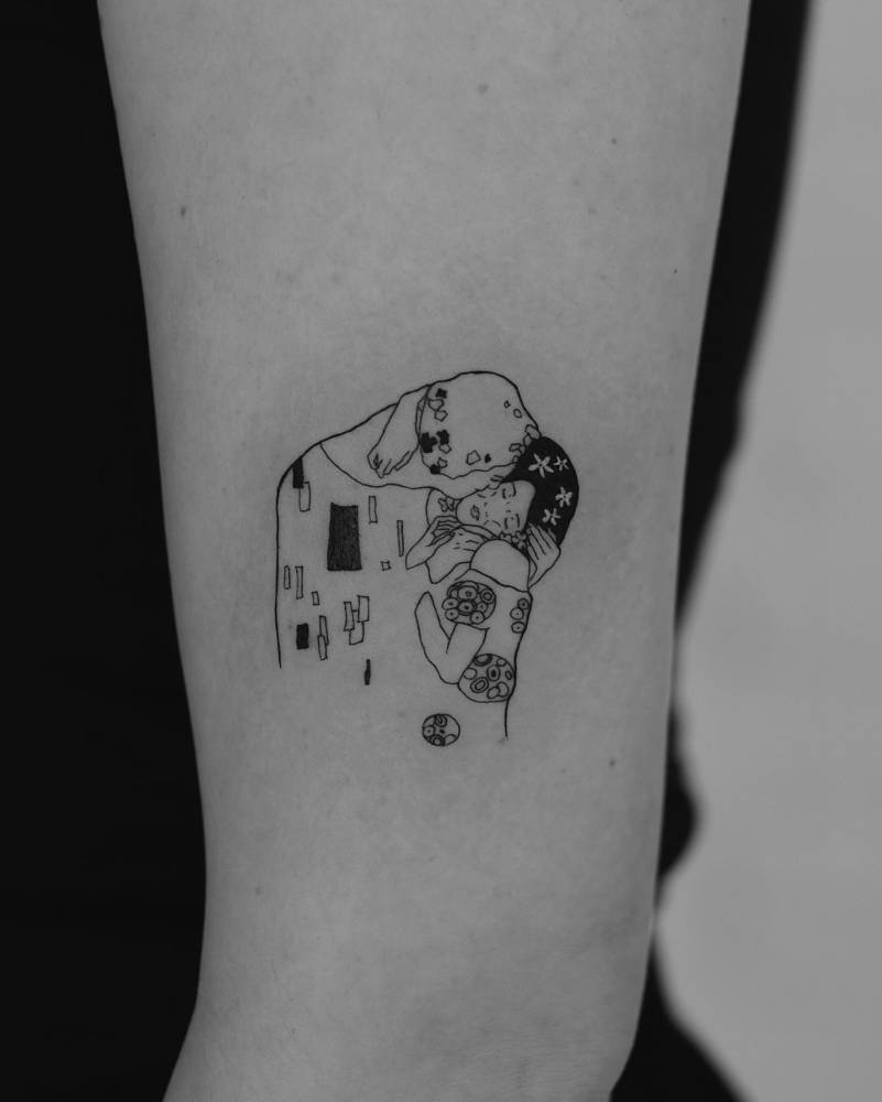 Klimt's 'The Kiss' tattoo located on the upper arm.