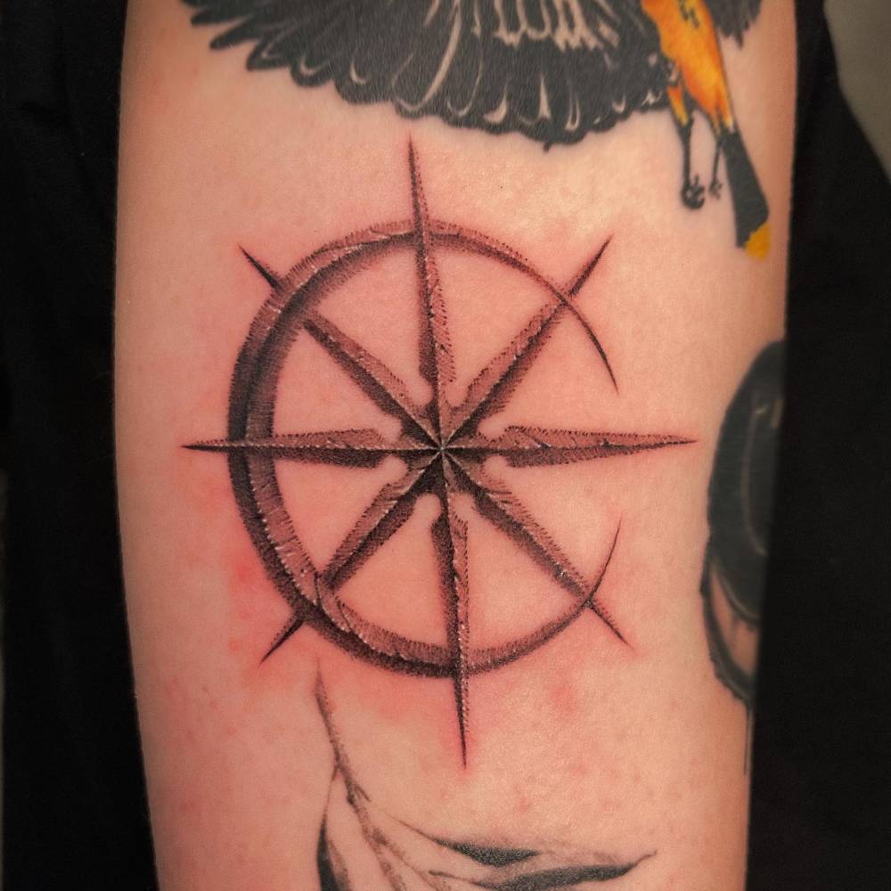 Dotwork style crescent moon and star tattoo placed on the upper arm.