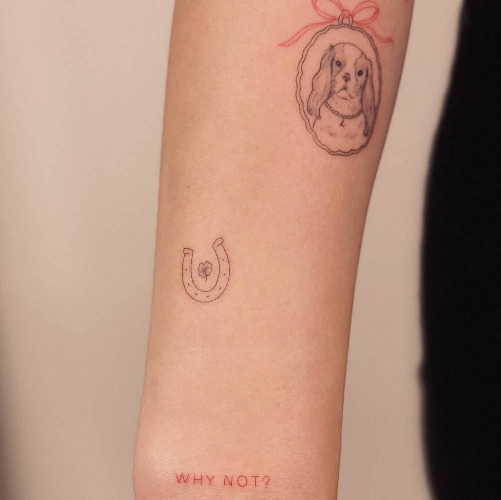 Horseshoe and dog portrait pendant tattoos located on the forearm.