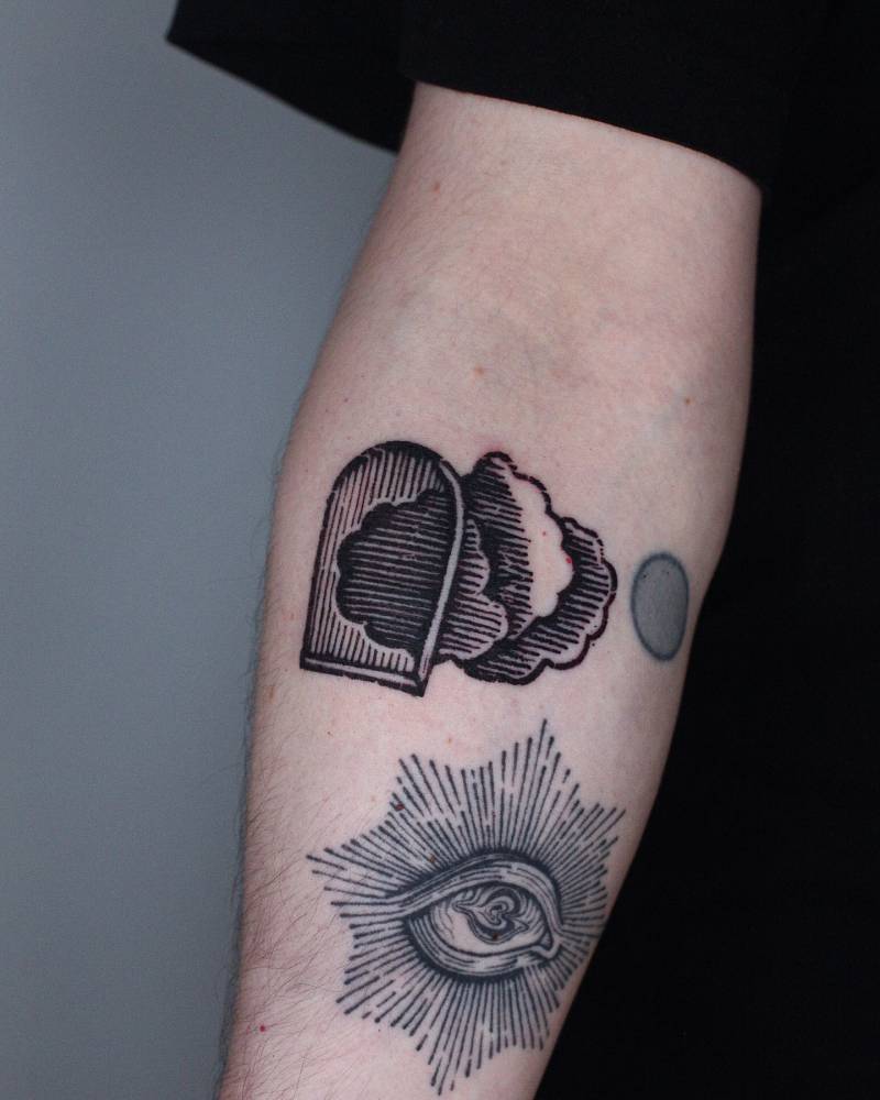 Engraving style window and clouds tattoo located on the inner forearm.