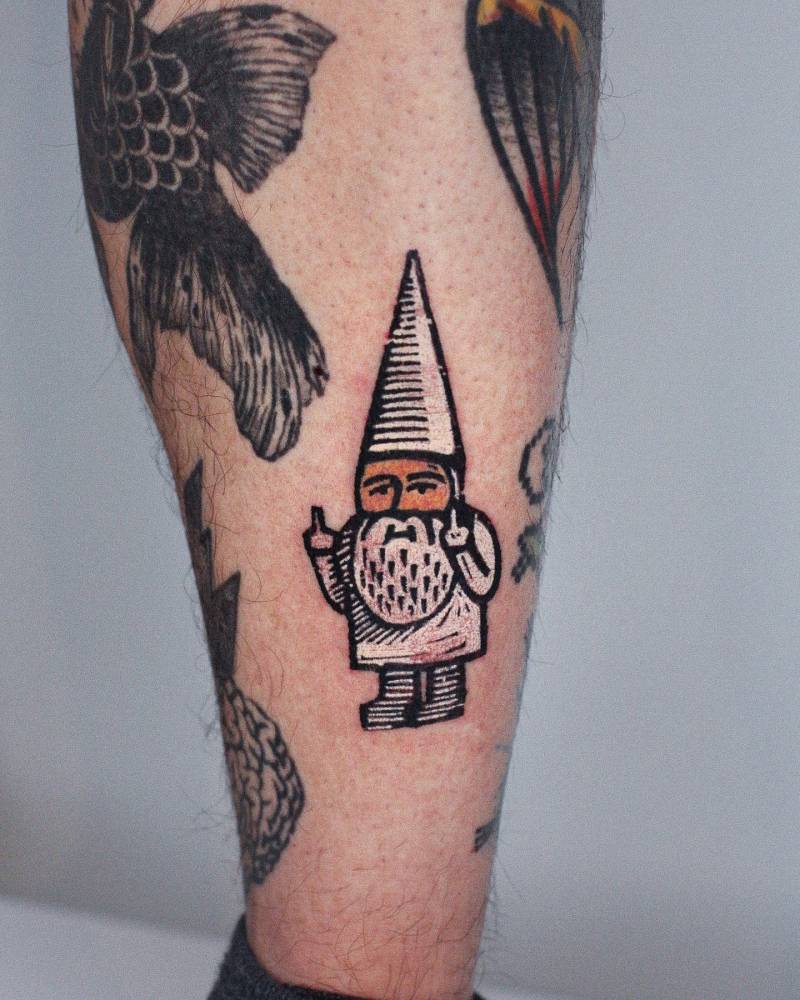 Pop art style gnome tattoo located on the shin.