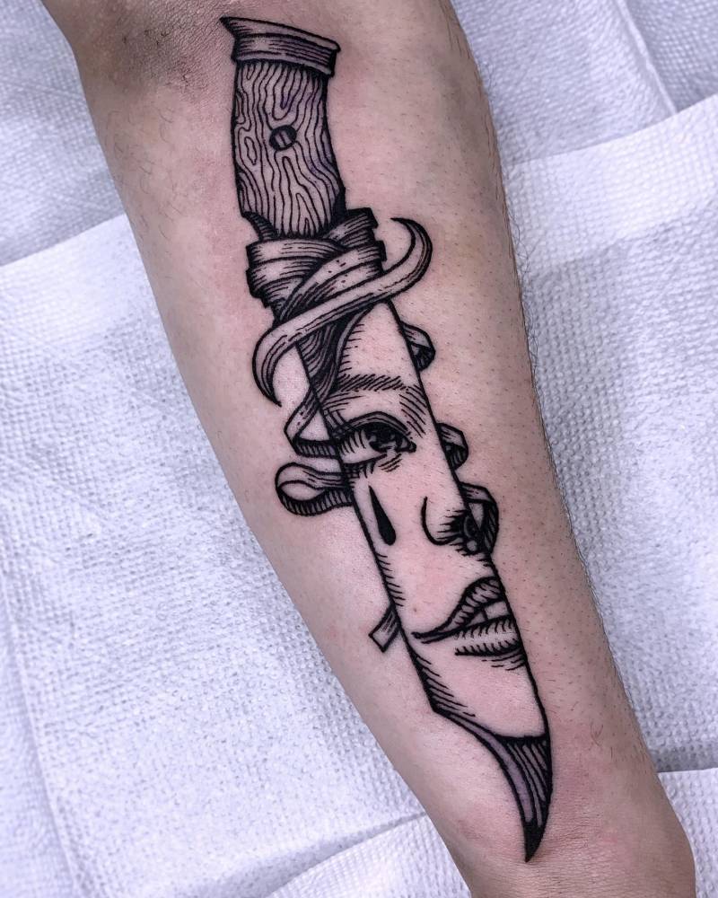 Knife and woman portrait tattoo located on the forearm, engraving style.