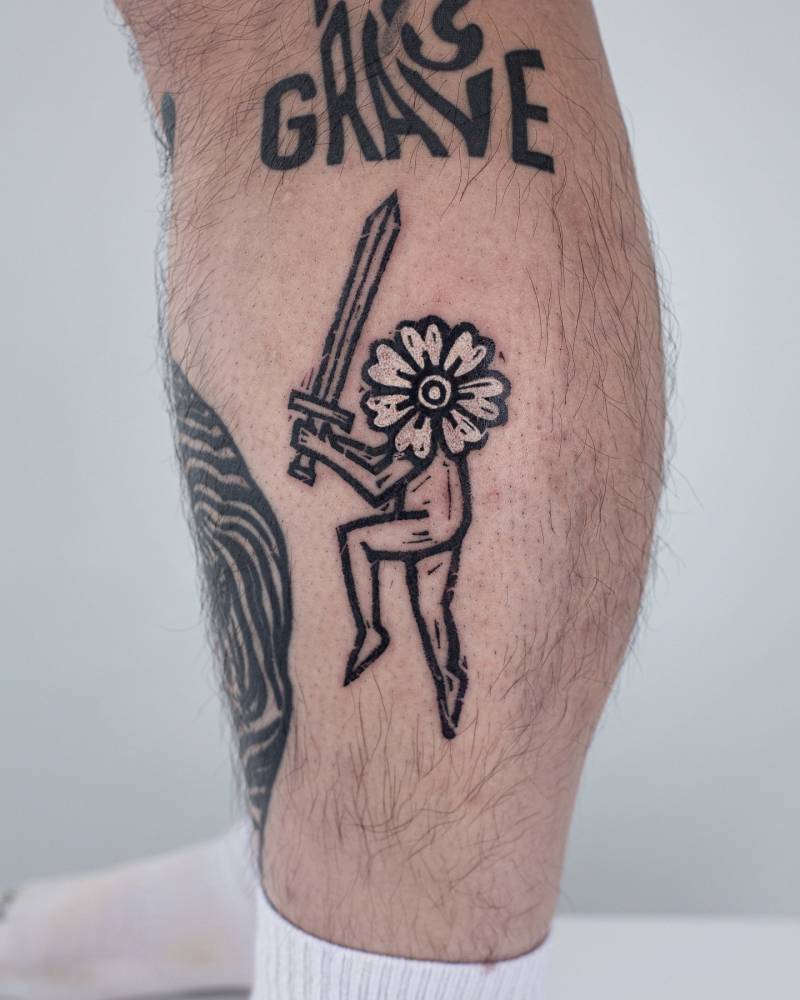 Flower head warrior tattoo located on the calf.