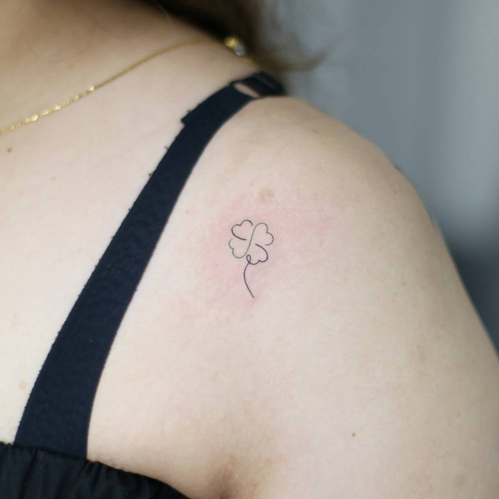 Four leaf clover tattoo in fine line style done on the shoulder