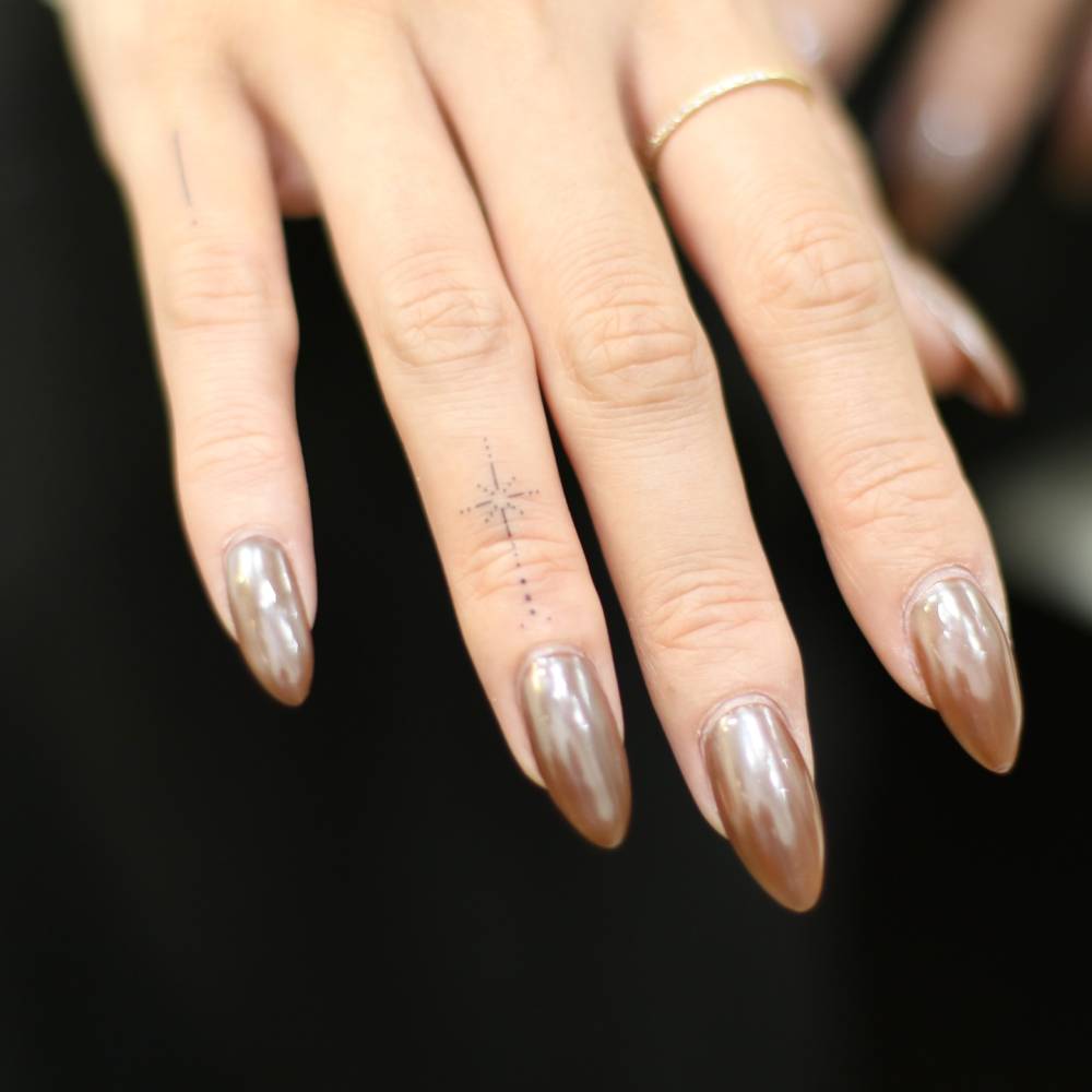 Minimalistic style north star tattoo located on the finger.