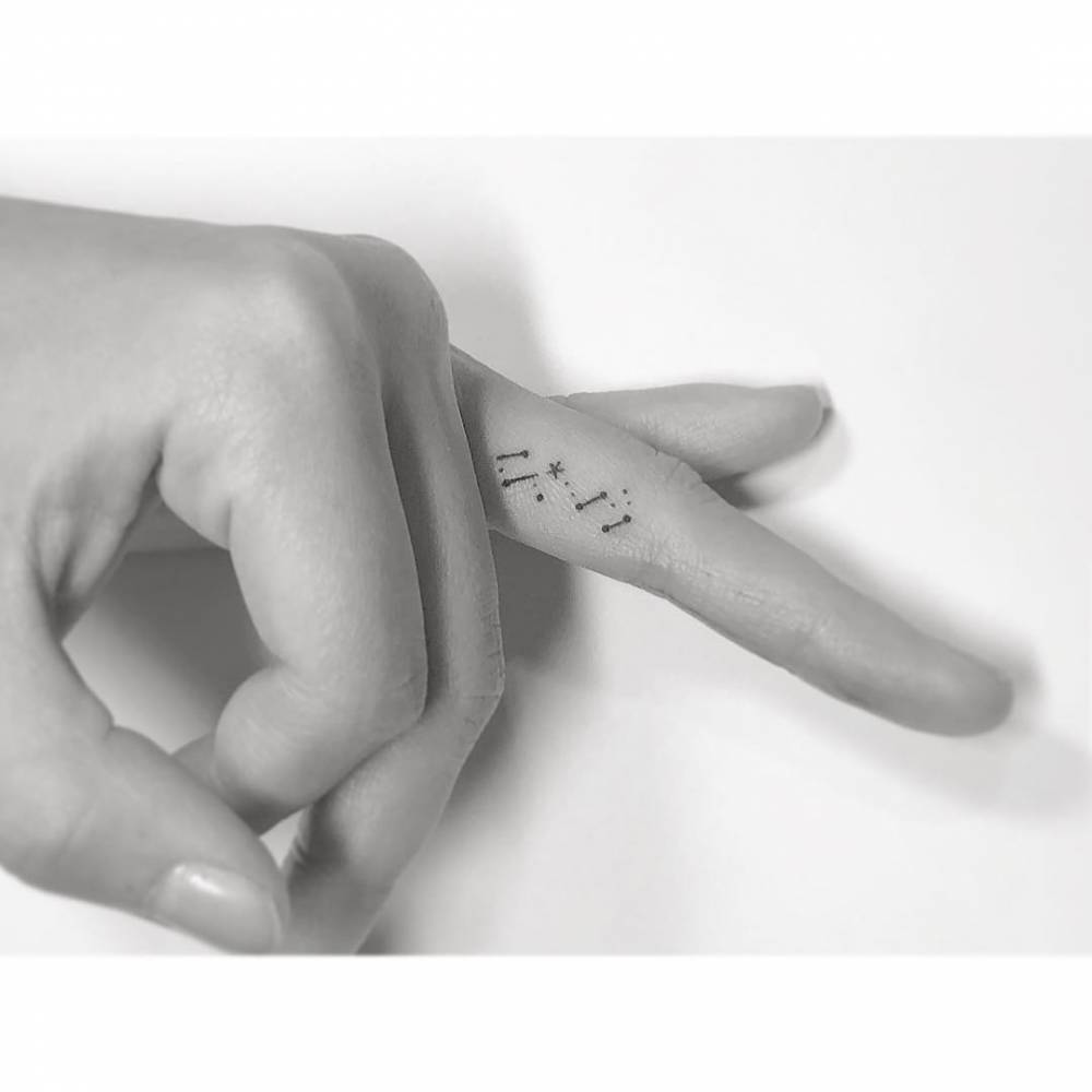 Scorpius constellation tattooed on the finger, minimalistic style.