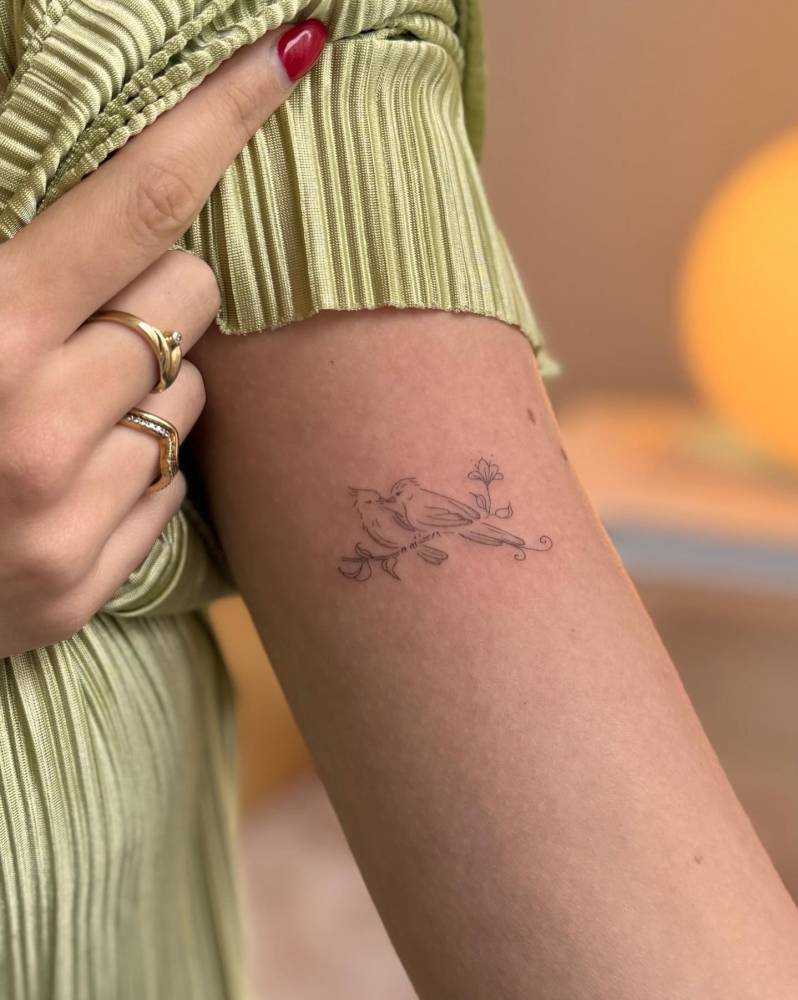 Birds on a branch tattoo in fine line style done on the bicep.