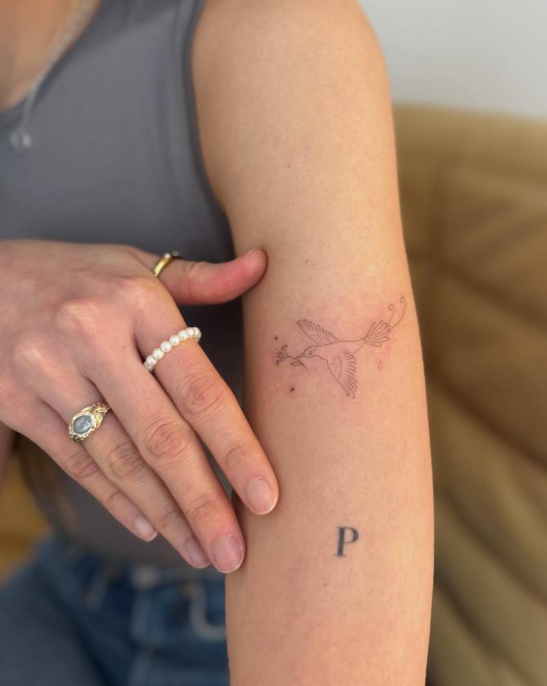 Dove tattoo in fine line style located on the forearm.