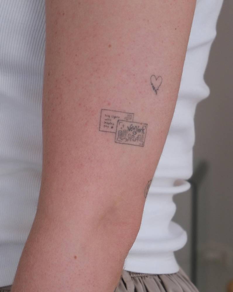 New York postcard tattoo located on the upper arm, healed.
