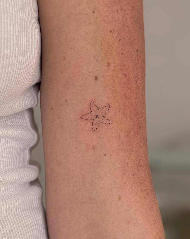 Starfish tattoo in fine line style done on the bicep.