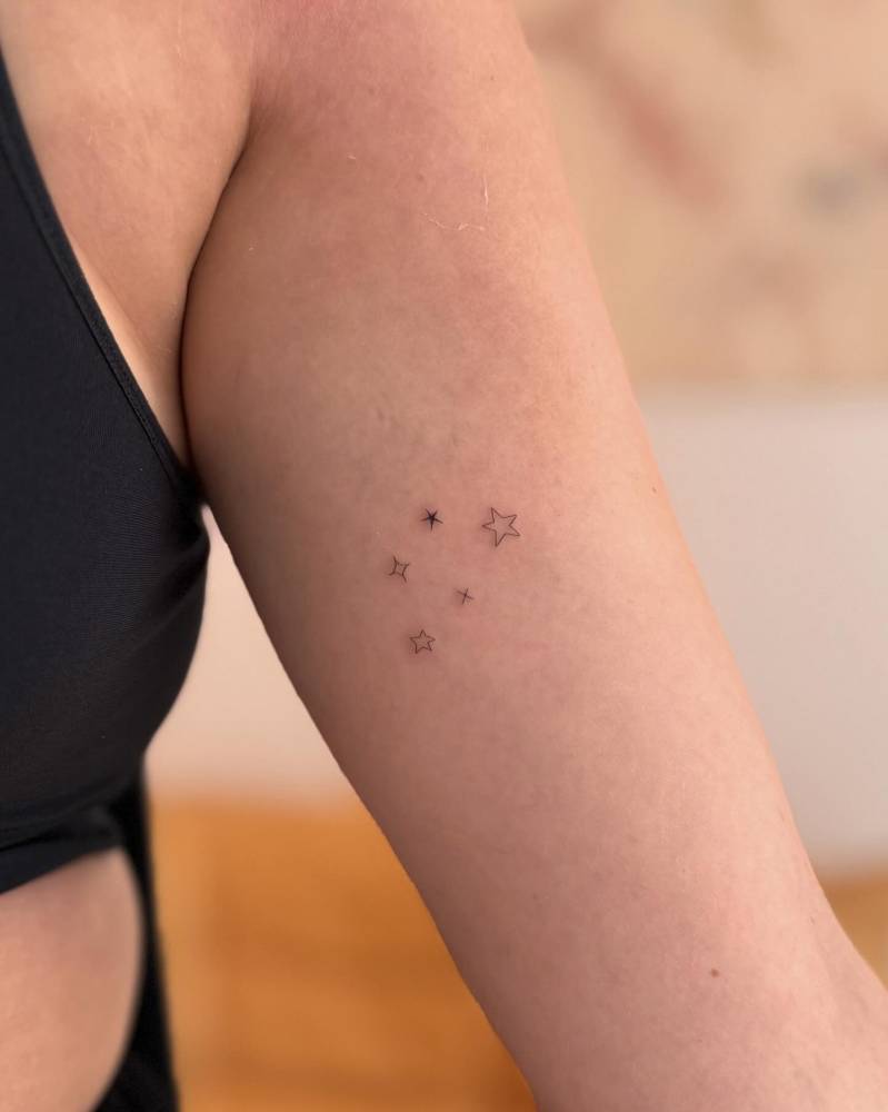 Stars tattoo located on the inner arm, minimalistic style.