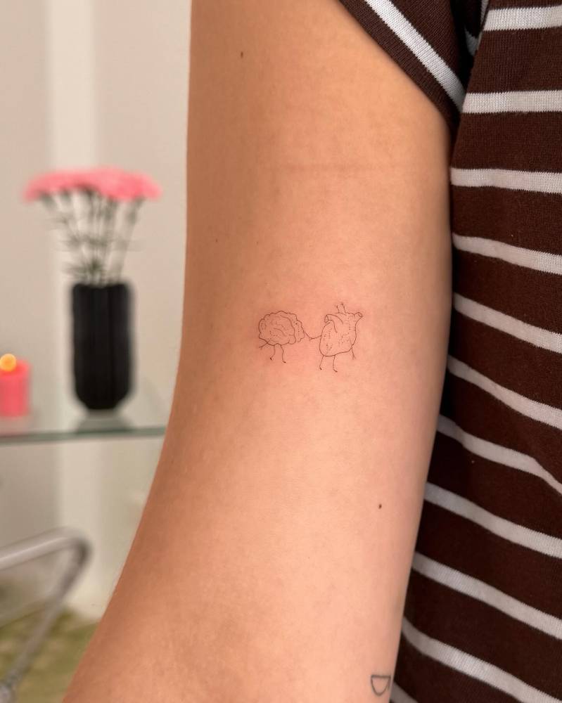 Heart vs. Brain tattoo in minimalistic style located on the bicep.