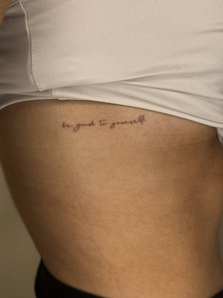 "Be good to yourself" lettering tattoo handwritten on the rib.