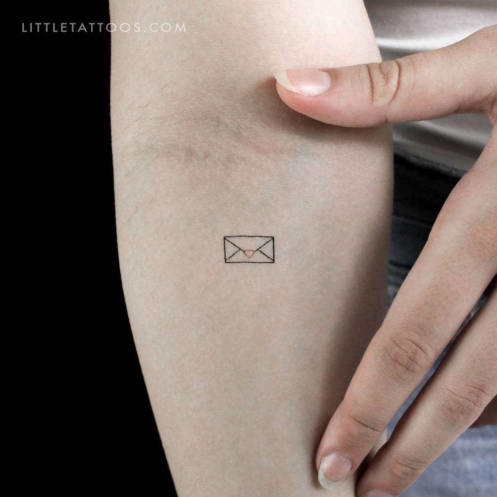 Tiny minimalistic love letter temporary tattoo located on the inner forearm.