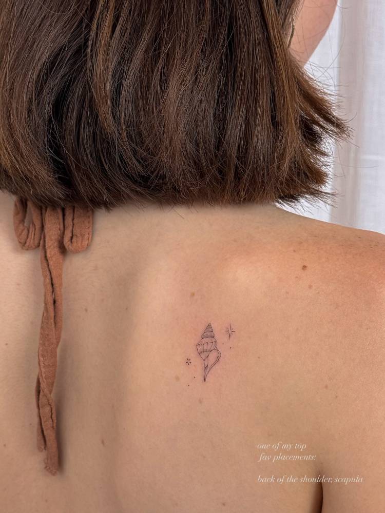 Tulip shell in fine line style tattooed on the shoulder blade.