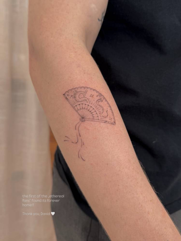 Cute hand fan tattoo placed on the forearm, done in fine line style.