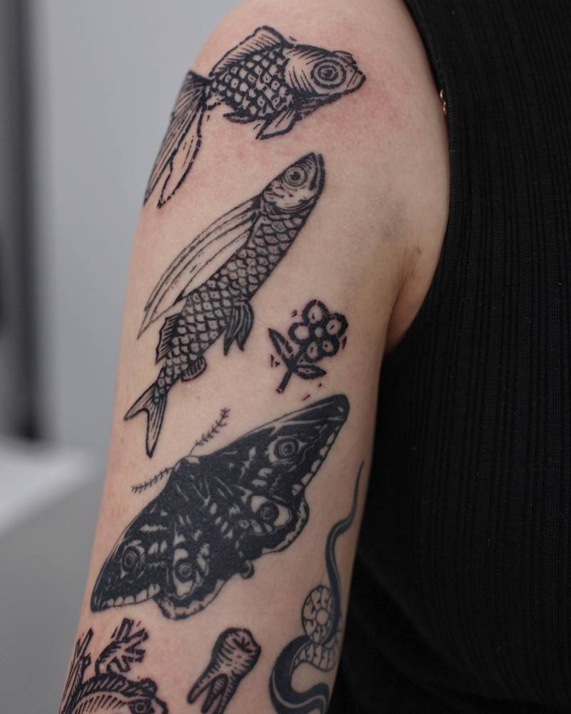 Fish tattoo in engraving style located on the shoulder.