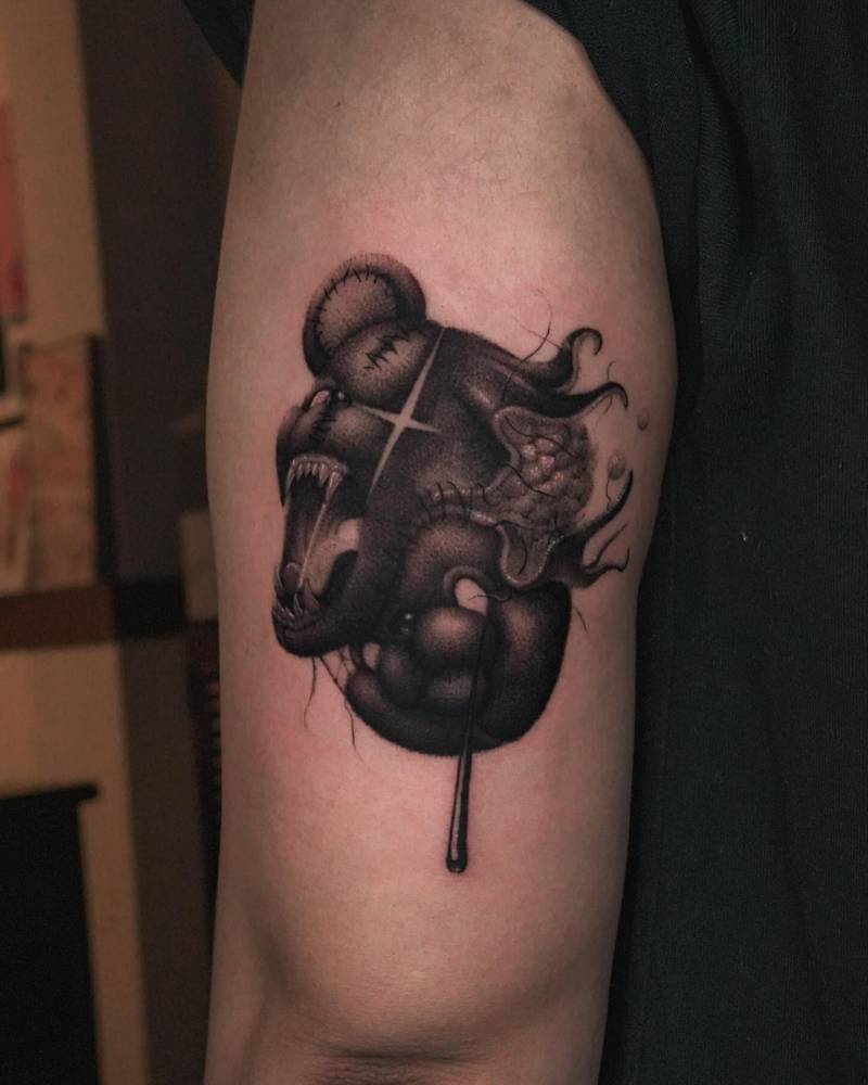 Scary teddy tattoo located on the tricep, dotwork style.