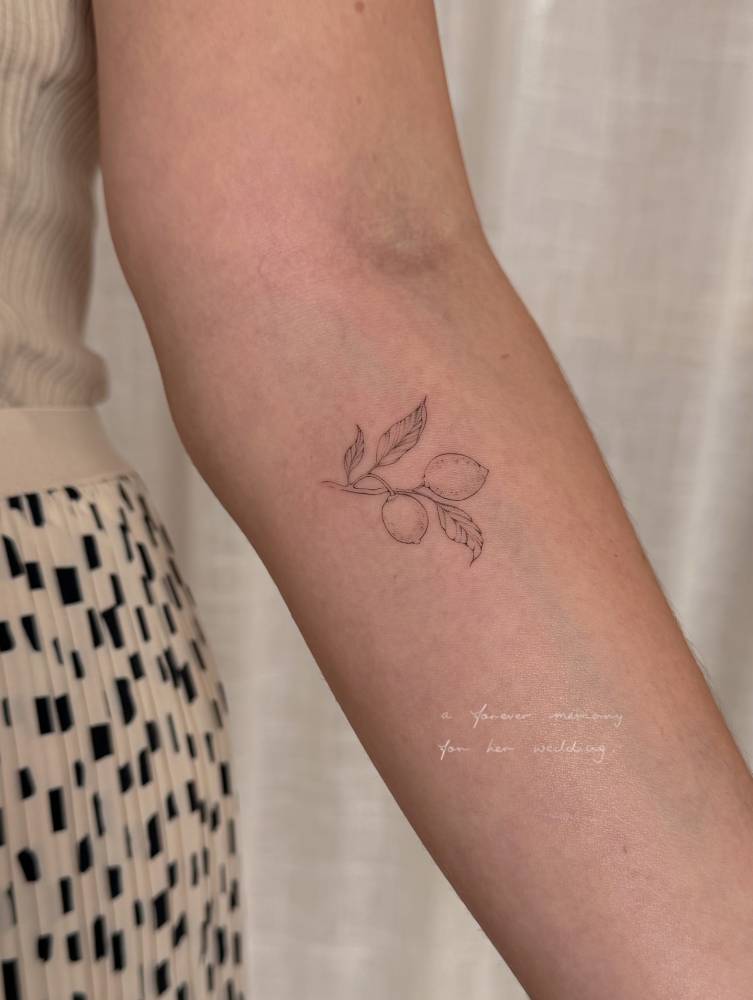 Fine line style lemons tattoo located on the inner forearm.